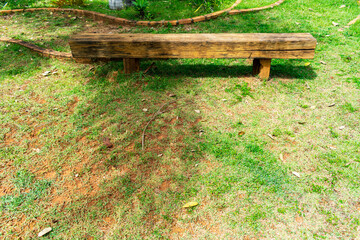 Wooden bench in garden in rural area. Ornamental plants. Lawn, trees and plants.Horizontal.