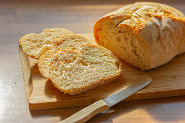 close up fresh white sliced bread and knife on wooden cutting board in the kitchen