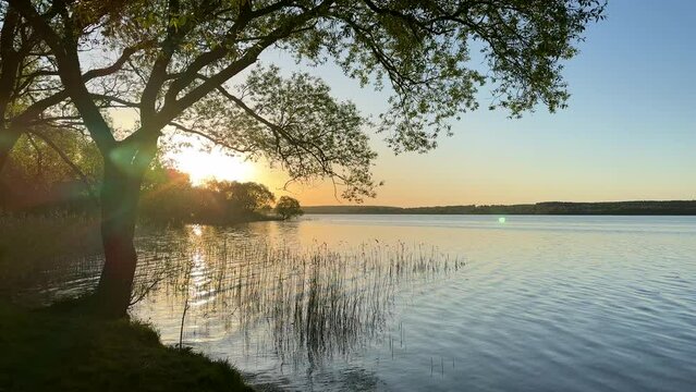 Sunset over the lake. Awesome Sunset with dramatic clouds  in the sky over sea. Lake in wild nature. 