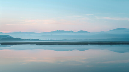 Serene Mountain Landscape with Calm Lake and Misty Horizon at Sunrise