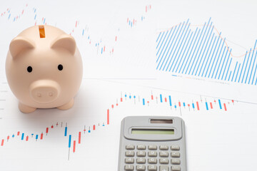 株価チャートと貯金箱と電卓で投資イメージ