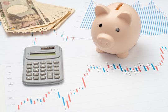 現金と株価チャートと貯金箱と電卓