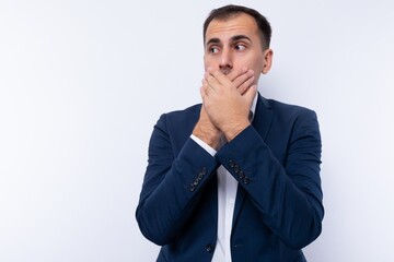 A 40-year-old brunette business man dressed in a blue jacket covered his mouth with his hands in surprise