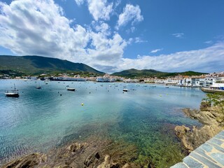 view over the Badia de Cadaqués, to the beautiful  white houses of Cadaqués, Port Alguer and the turquoise water of the Mediterranean Sea, mountains of the Pyrenees behind, Girona, Catalonia, Spain