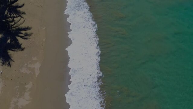 Playa vista desde el cielo acercandose con las olas en movimiento color verde turquesa