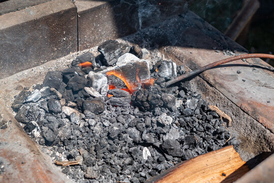 Calor da antiguidade: Fornalha medieval com um ferro incandescente pronto para ser forjado