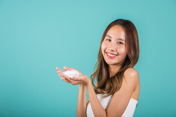 Portrait Asian young woman hands are adorned with white foam mousse studio shot isolated on blue...