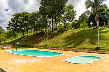 Children's and adult pool. Trees. Lampposts. Cloudy sky. Decoration.