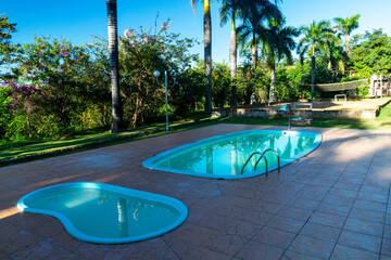 Children's and adult pool. Trees. Lampposts. Cloudy sky. Decoration.
