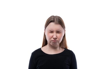 A school-age girl dressed in black clothes closed her eyes on a white background