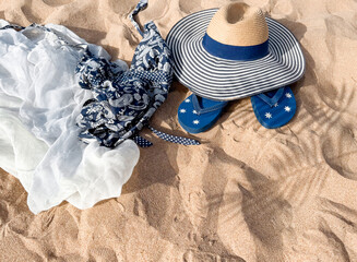 Beach Accessories on Sand - Hat, Flip Flops, Bag, and Shells for Summer Vacation.