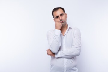 Pensive handsome Caucasian man in a white shirt on a white background