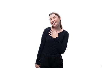 A school-age girl with brown hair laughs and is shy on a white background