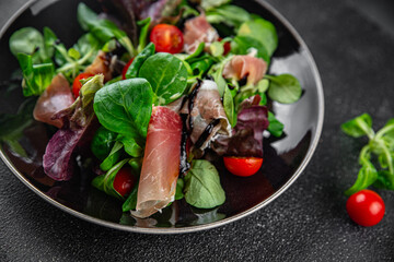 jamon salad green leaf lettuce, tomato, salad dressing appetizer meal food snack on the table copy space food background rustic top view keto or paleo diet