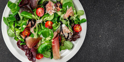 jamon salad green leaf lettuce, tomato, salad dressing appetizer meal food snack on the table copy space food background rustic top view keto or paleo diet