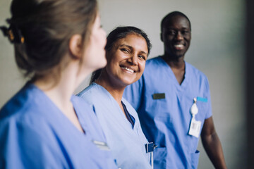 Happy multiracial male and female medical professionals in hospital