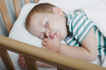 Toddler boy sleeping close-up on bed. Health care concept