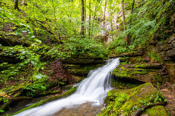 Waterfall near the exit of the &ldquo;Falkensteiner H&ouml;hle&rdquo; (Falkenstein cave) near Bad Urach (Germany). Karst creek with high level in May from an underground river under &ldquo;Sch&auml;bische Alb&rdquo; plateau.
