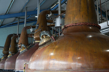 Copper stills in a whisky distillery. The giant copper stills are used to distil the alcohol in a...