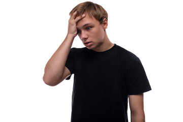Naklejka premium European blond teenager boy dressed in a black T-shirt thinks about an idea