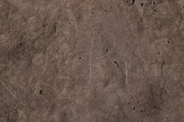 Scratches and writing on dark cement