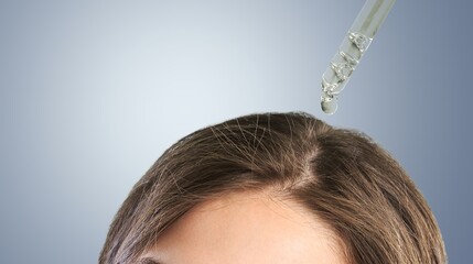 A young woman hand applies oil drop to hair