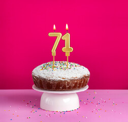 Lighted birthday candle number 71 - Birthday card on pink background