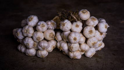 White garlic is stacked in circles on the cement floor.