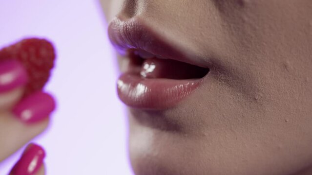 Kobieta zjada owoc maliny