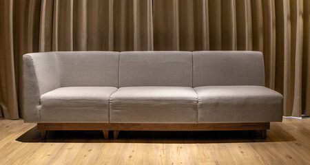 ​Sofa in a contemporary room with brown leather upholstery, against a curtain backdrop, creating a comfortable and stylish interior