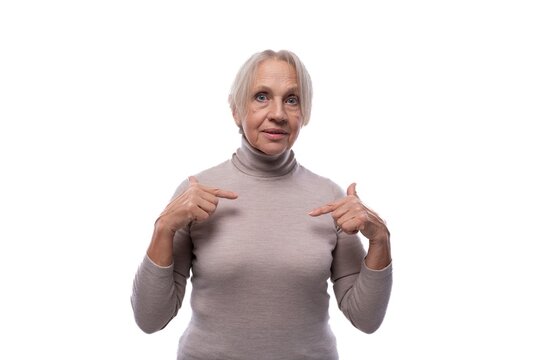 65 year old pensioner woman with short hair pointing with fingers