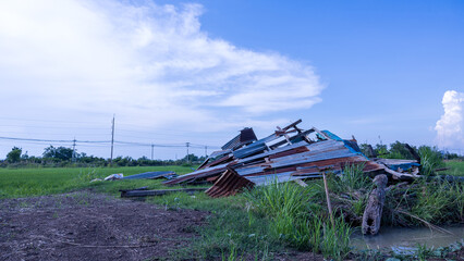 Fototapeta premium A view of an old wooden hut with a zinc sheet roof collapsed.
