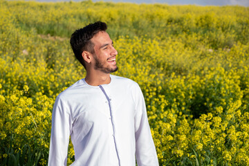 Arabian male enjoy healthy lifestyle in nature between yellow flowers in the field having fresh air...