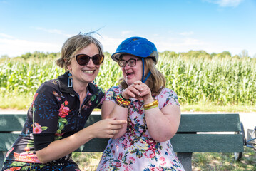 Down Syndrome woman connecting with her friends, both wearing a summer dress, Hakendover, Belgium