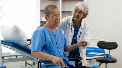 Obraz premium Elderly Asian man doing physical therapy with support from a senior female therapist nurse. Elderly man using elastic band to exercise for patient in home nursing, health care concept.