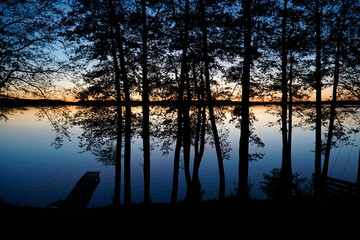 Sunset over lake with trees at shore