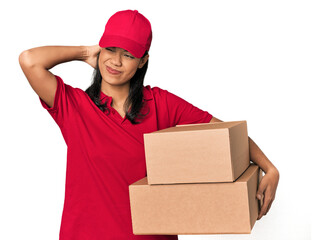 Young Filipina courier with two packages touching back of head, thinking and making a choice.