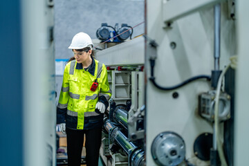 female engineers in neat work clothes prepare and control the production system of large modern machines in a factory producing industrial technology products.