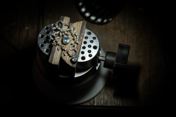 Different goldsmiths tools on the jewelry workplace. Jeweler at work in jewelry. Desktop for craft...