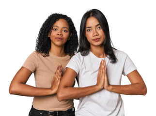 Young Latin friends in studio praying, showing devotion, religious person looking for divine inspiration.