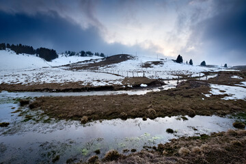 Vezzena plateau: seasonal stream between meadows and the Basson hill. Levico Terme, Trentino, Italy.