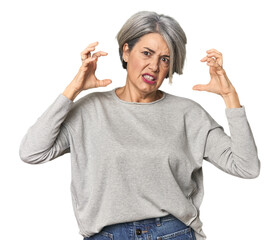 Caucasian mid-age female on studio background screaming with rage.