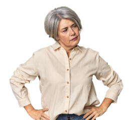 Caucasian mid-age female on studio background confused, feels doubtful and unsure.