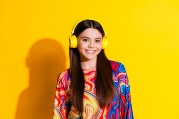 Photo portrait of pretty young girl headphones listen music wear trendy colorful outfit isolated on yellow color background