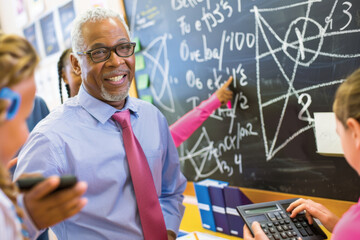 Teacher at school against the background of children and board. Back to school concept.