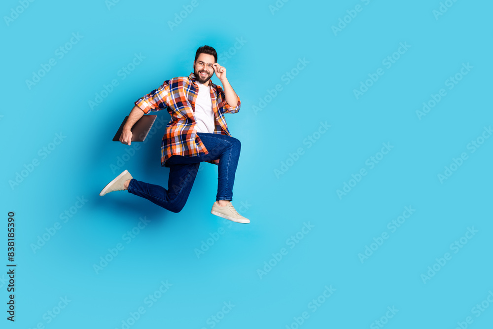 Poster Full size photo of nice young man laptop run jump wear shirt isolated on blue color background