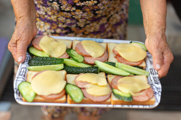 Mature lady holding a tray full of food.
