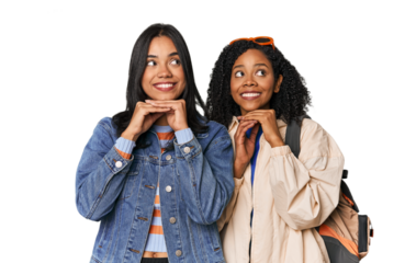 Latin friends ready for vacation keeps hands under chin, is looking happily aside.