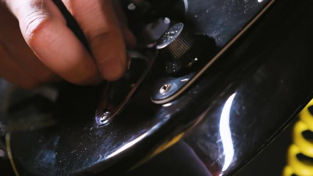 Close-up of the guitar's input jack and control knob. A guitarist plugs a jack into the jack of a black electric guitar. Plugging in the guitar before starting a concert or rehearsal