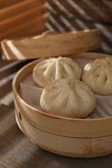 Fototapeta premium Delicious bao buns (baozi) on wooden table, closeup
